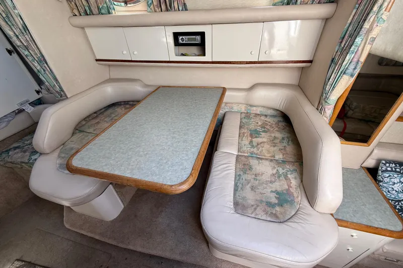 Slide: The Image of Interior of 1996 Sea Ray 330 Sundancer with dining area and cushioned seating. - 37