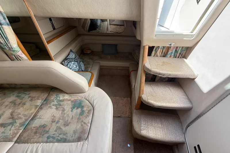Slide: The Image of Interior of 1996 Sea Ray 330 Sundancer, featuring cozy seating and carpeted steps. - 38