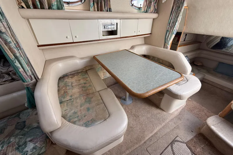 Slide: The Image of 1996 Sea Ray 330 Sundancer interior with cozy dining area and cushioned seating. - 39