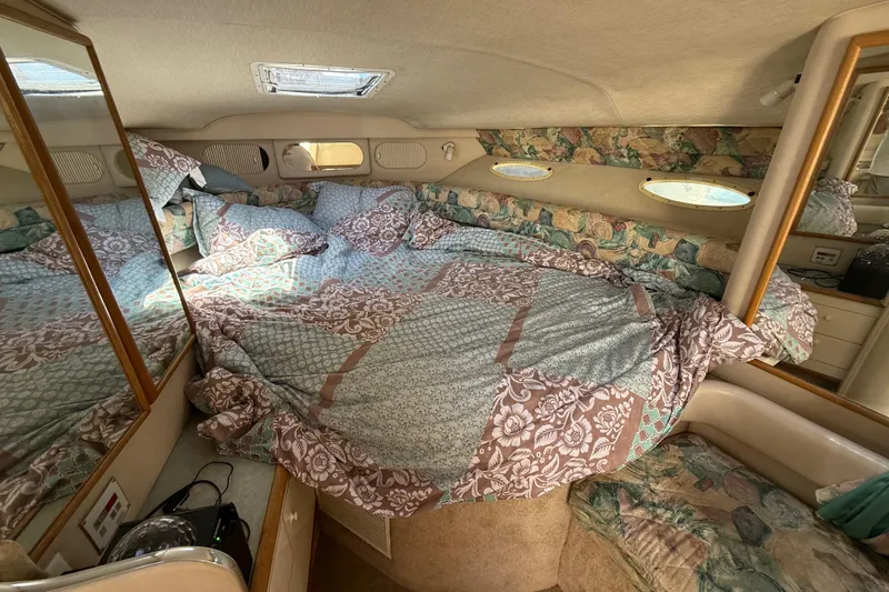 Slide: The Image of Cozy cabin interior of 1996 Sea Ray 330 Sundancer with floral bedding and porthole windows. - 41