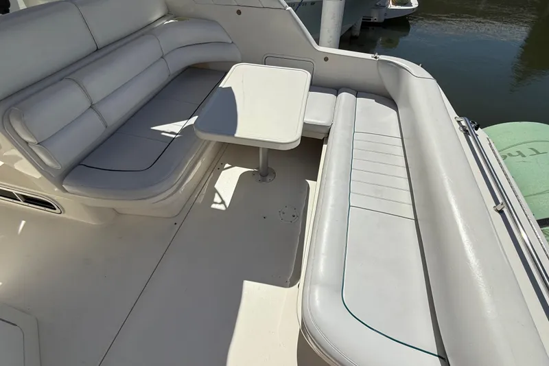 Slide: The Image of 1996 Sea Ray 330 Sundancer boat interior with white seating and table. - 5