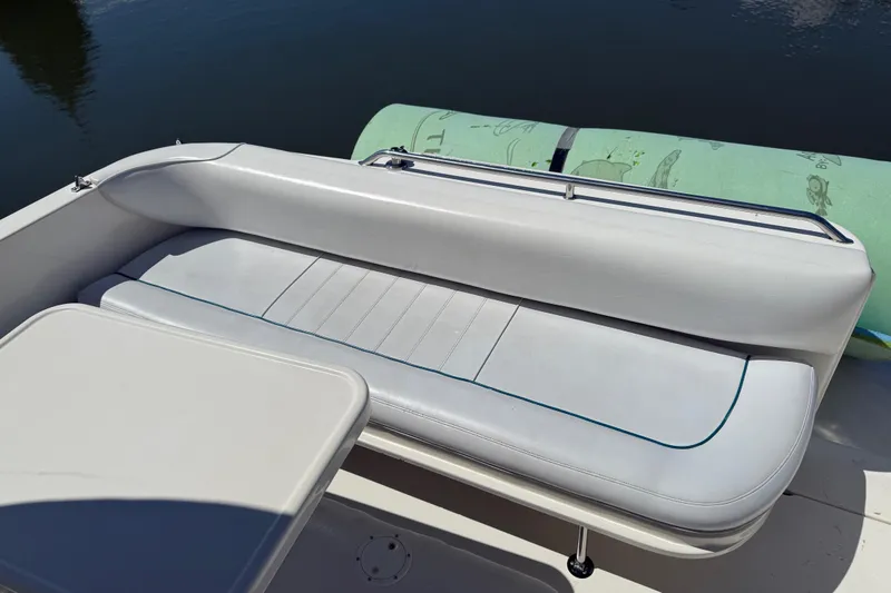 Slide: The Image of 1996 Sea Ray 330 Sundancer boat seating area with white upholstery and table. - 6