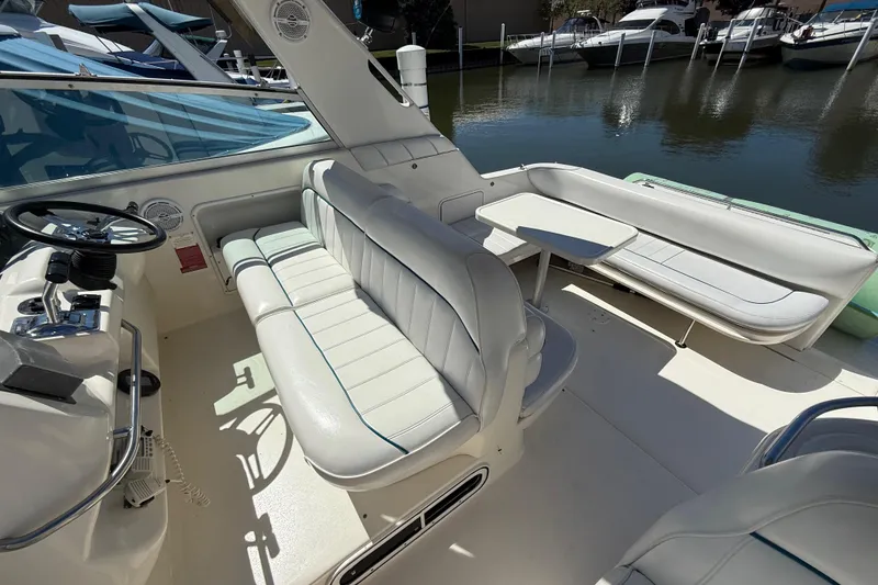 Slide: The Image of 1996 Sea Ray 330 Sundancer boat interior with white seating and steering wheel. - 9