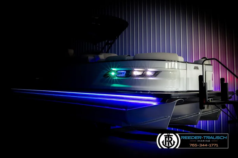 Slide: The Image of 2026 Avalon Excal LTD CRB boat with vibrant LED lights in a dimly lit setting. - 4