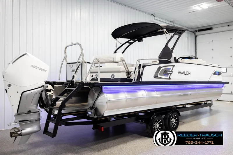 Slide: The Image of 2026 Avalon Excal LTD CRB boat with Mercury engine, displayed indoors on a trailer. - 6