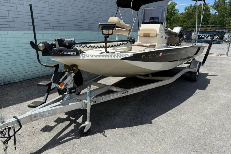 Slide: The Image of 2022 Xpress H20 BAY boat on trailer with Minn Kota motor, parked outdoors. - 2