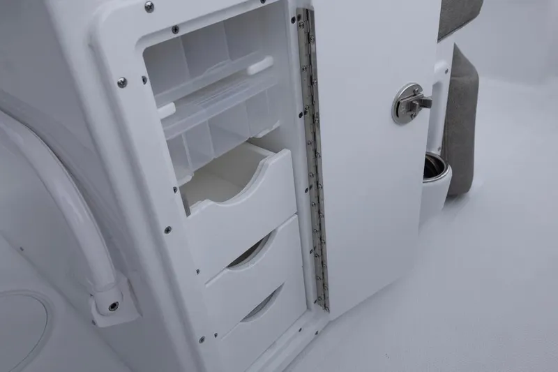 Slide: The Image of 2026 Sea Hunt Ultra 265 SE boat storage compartment with open door and shelves. - 14