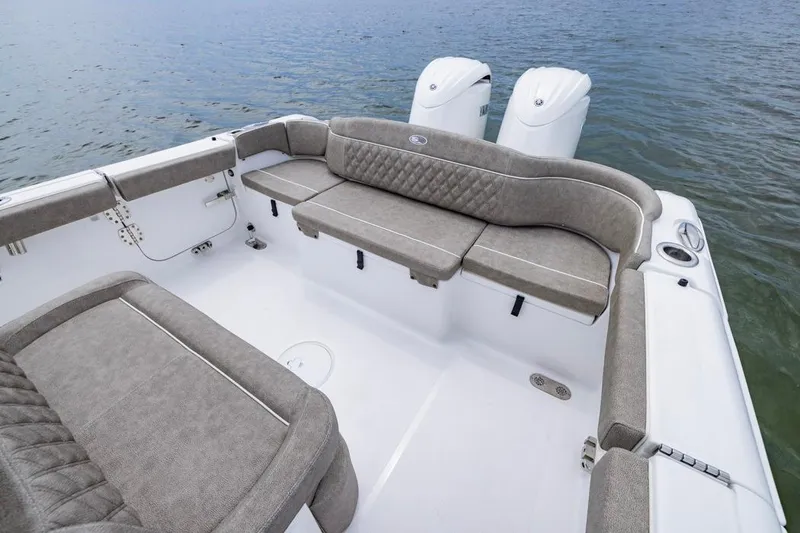 Slide: The Image of 2026 Sea Hunt Ultra 265 SE boat interior with cushioned seating and twin engines. - 17