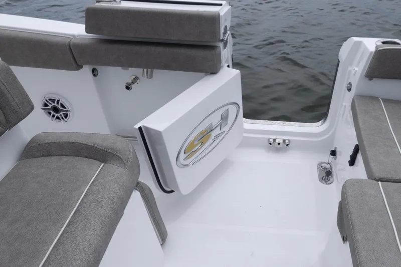Slide: The Image of 2026 Sea Hunt Ultra 265 SE boat interior with gray seating and open side door. - 18