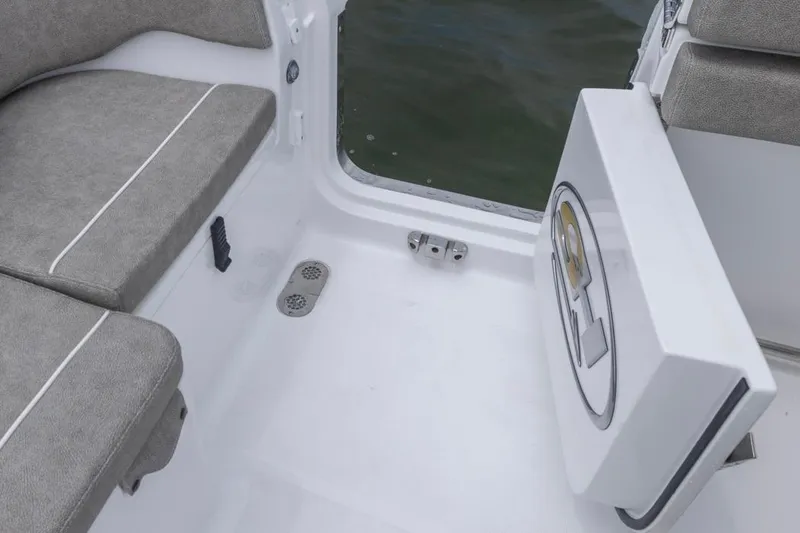 Slide: The Image of 2026 Sea Hunt Ultra 265 SE boat interior with cushioned seating and storage compartment. - 23