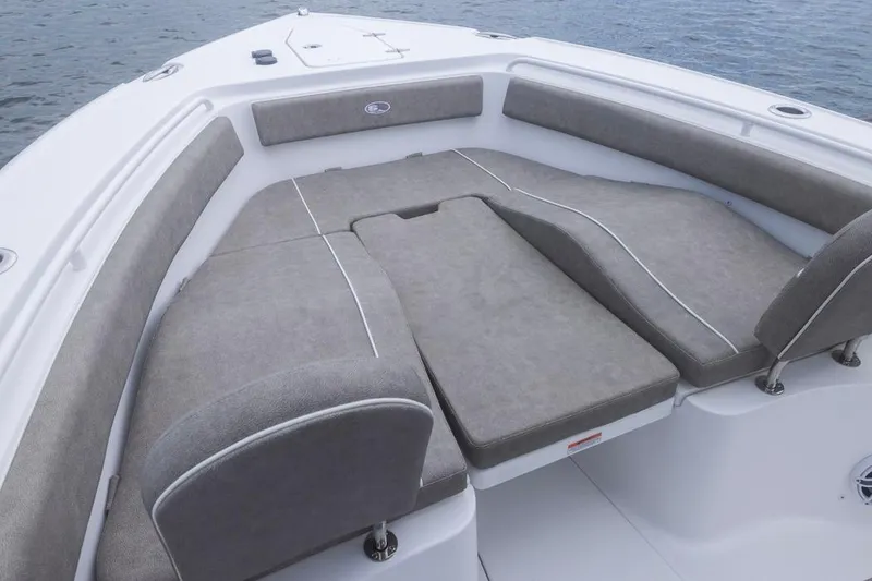 Slide: The Image of 2026 Sea Hunt Ultra 265 SE boat interior with cushioned seating, on calm water. - 5