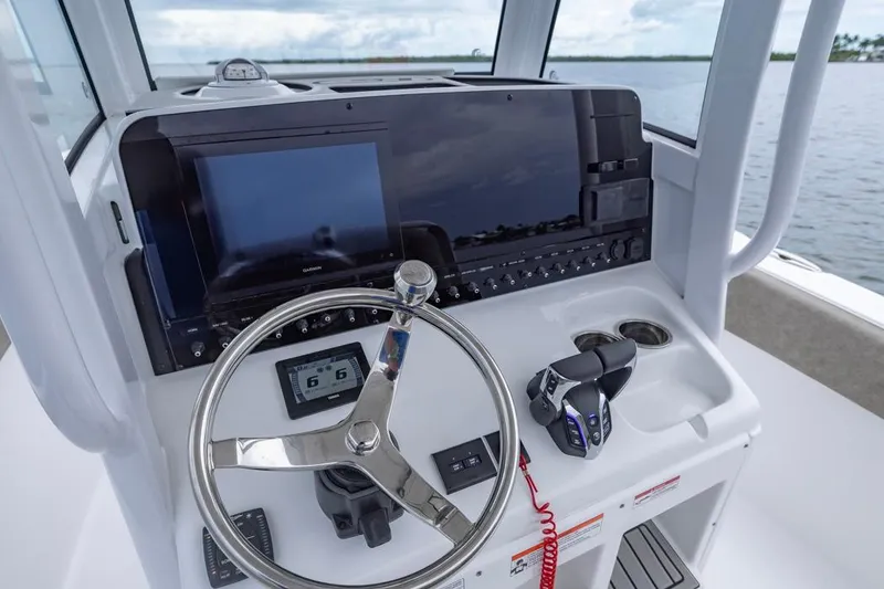 Slide: The Image of 2026 Sea Hunt Ultra 265 SE helm with steering wheel and navigation controls. - 7