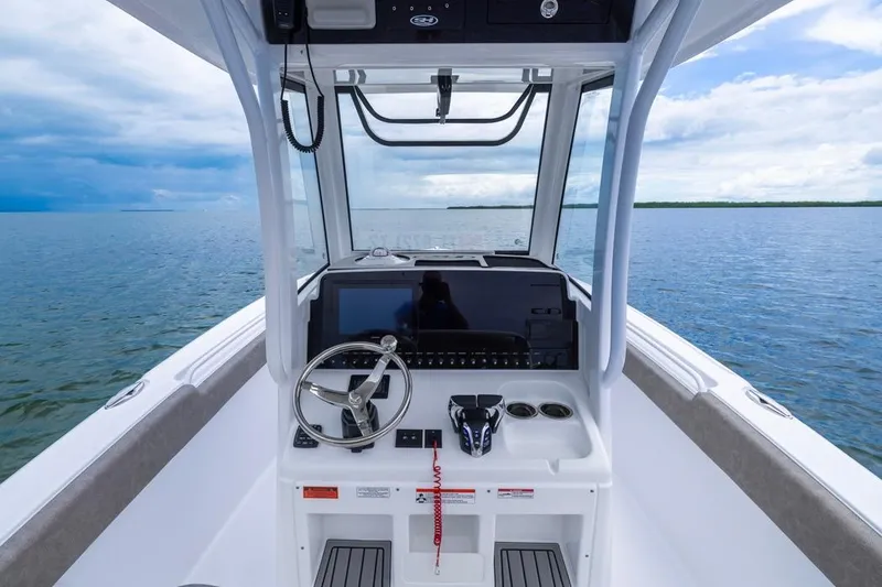 Slide: The Image of 2026 Sea Hunt Ultra 265 SE boat helm with steering wheel, controls, and ocean view. - 9