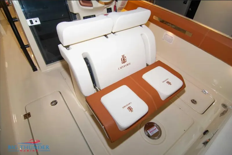 Slide: The Image of 2024 Capoforte FX270 boat interior with white and brown seating, featuring Capoforte branding. - 11