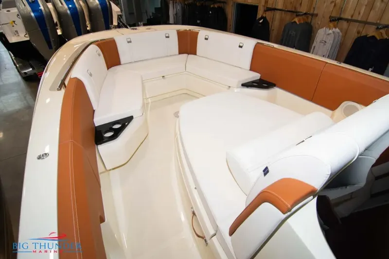 Slide: The Image of 2024 Capoforte FX270 boat interior with white and tan seating, cup holders, and modern design. - 23