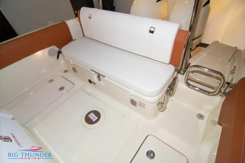 Slide: The Image of 2024 Capoforte FX270 boat interior with white seating and storage compartment. - 7
