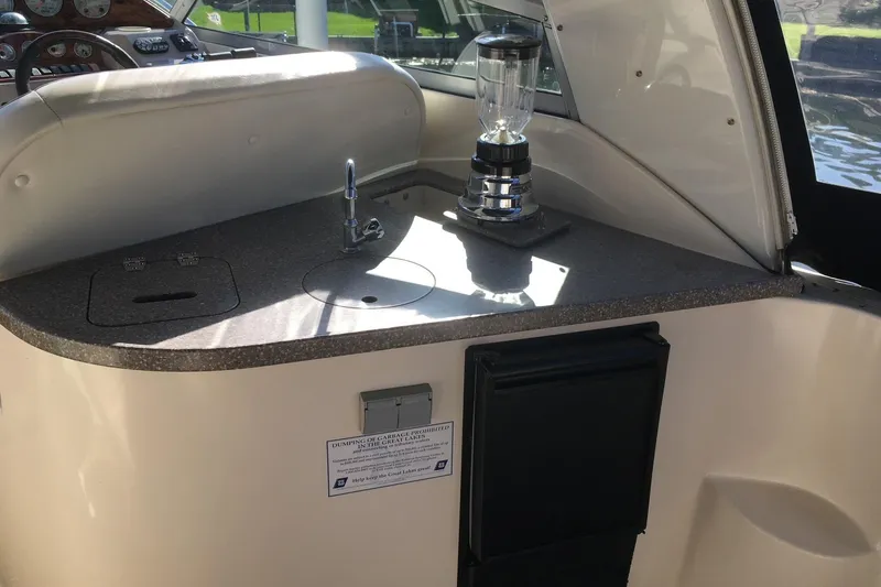Slide: The Image of Interior of 2004 Rinker Fiesta Vee 312 with beige seating and a granite-style table. - 4
