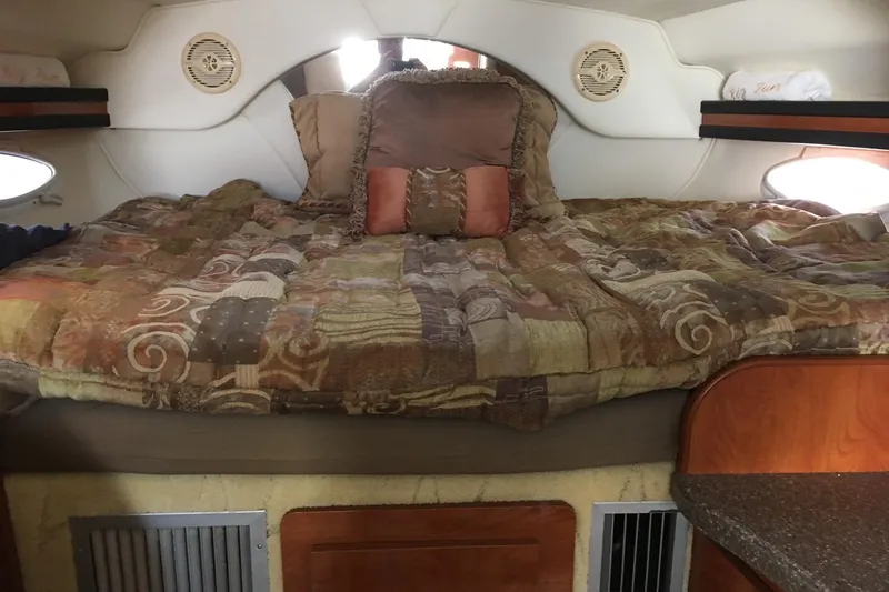 Slide: The Image of Interior of 2004 Rinker Fiesta Vee 312 with flowers on table, cozy seating, and bed. - 6