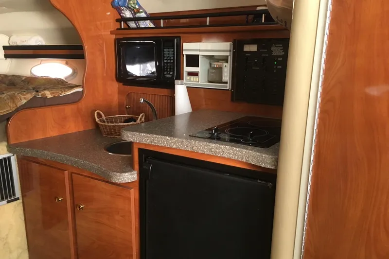 Slide: The Image of Cozy cabin interior of 2004 Rinker Fiesta Vee 312 with patterned bedding. - 7