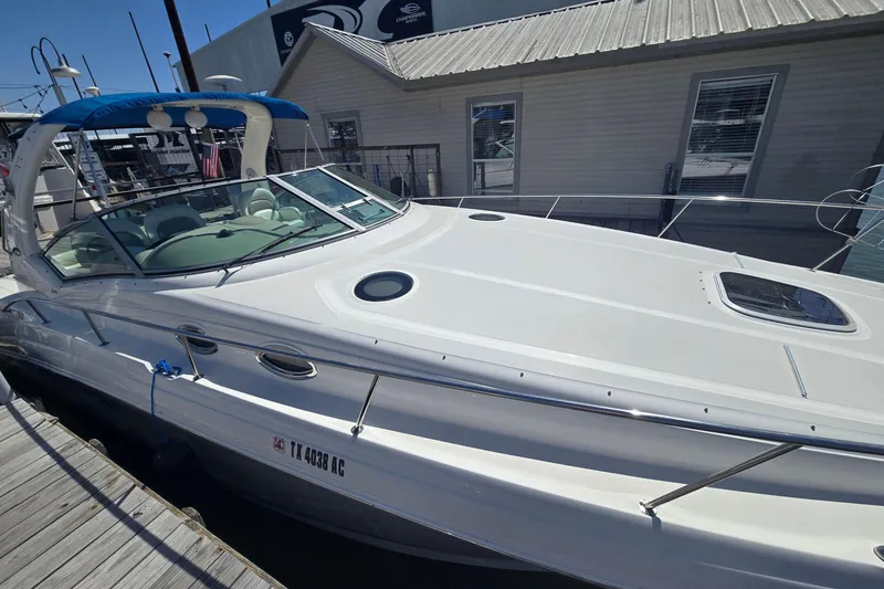 The Image of 2003 Sea Ray 340 Sundancer docked, showcasing sleek design and spacious deck. - 0