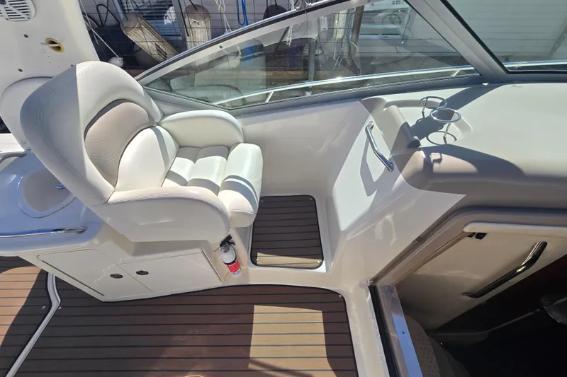 Slide: The Image of 2003 Sea Ray 340 Sundancer cockpit with white captain's chair and wooden flooring. - 16