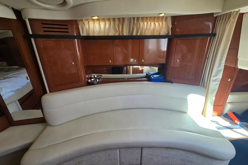 Slide: The Image of Luxurious interior of 2003 Sea Ray 340 Sundancer with curved seating and wooden cabinetry. - 23