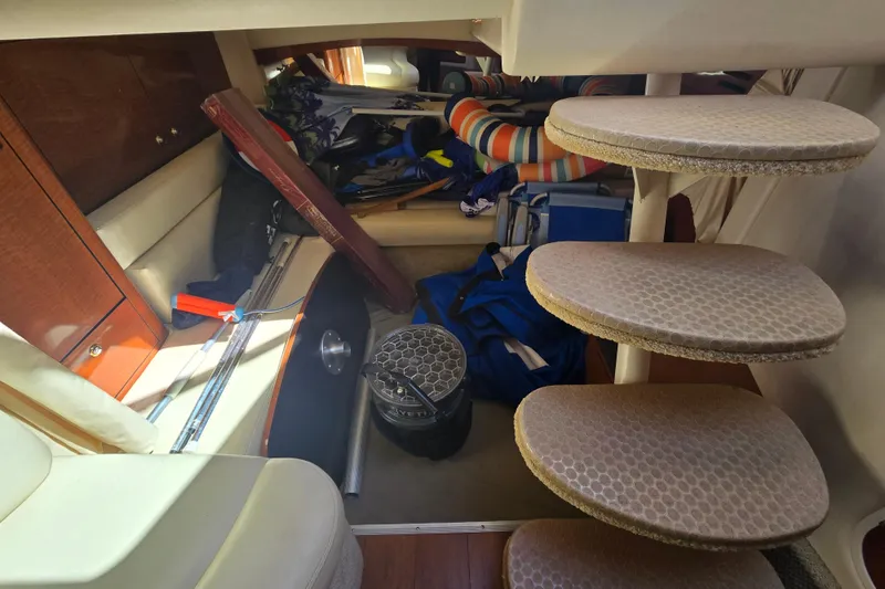 Slide: The Image of Interior of 2003 Sea Ray 340 Sundancer with cluttered storage and spiral staircase. - 25