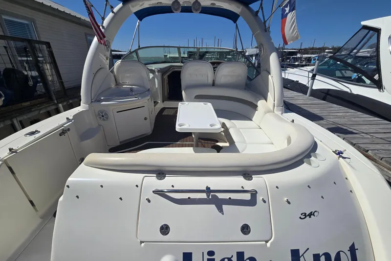 Slide: The Image of 2003 Sea Ray 340 Sundancer yacht with spacious seating and table, docked at marina. - 4