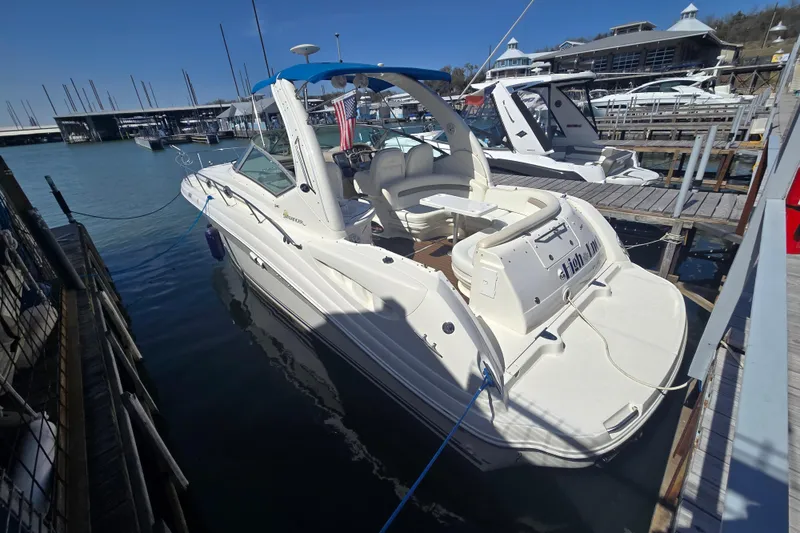 Slide: The Image of 2003 Sea Ray 340 Sundancer docked at marina, featuring spacious deck and seating area. - 5