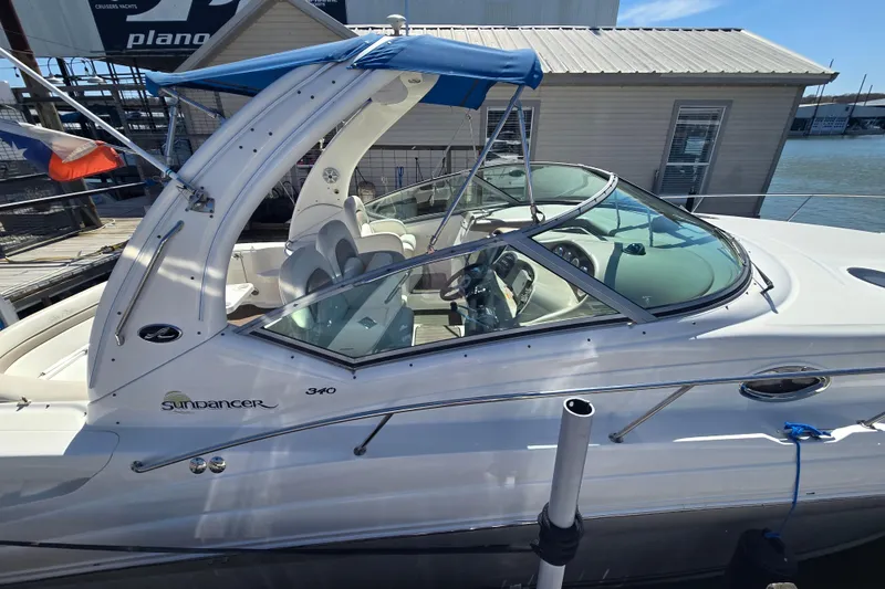 Slide: The Image of 2003 Sea Ray 340 Sundancer boat docked, featuring sleek design and blue canopy. - 6