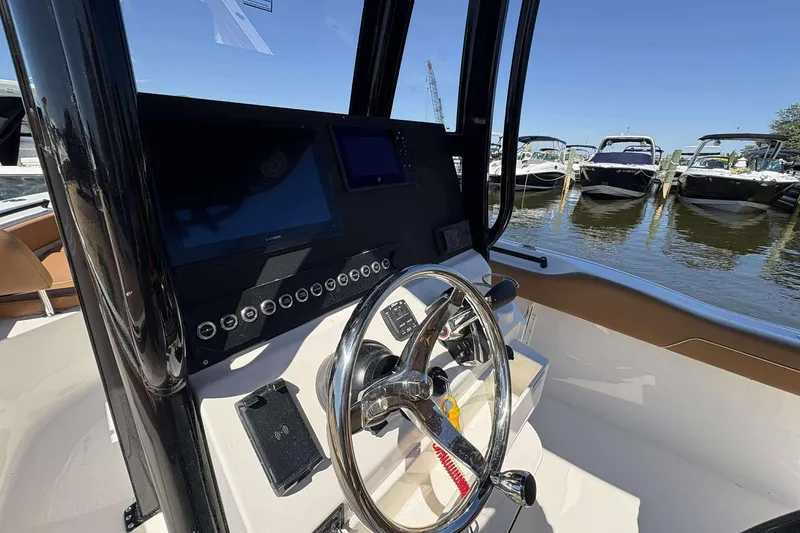 Slide: The Image of 2026 Key West 239 FS boat dashboard with steering wheel, docked at marina. - 11