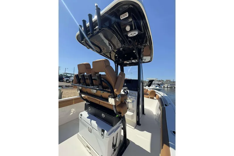 Slide: The Image of 2026 Key West 239 FS boat interior with seating and storage, docked under clear blue sky. - 12