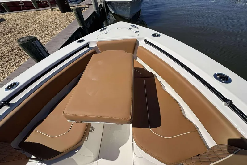 Slide: The Image of 2026 Key West 239 FS boat interior with tan seating and table, docked by the water. - 15