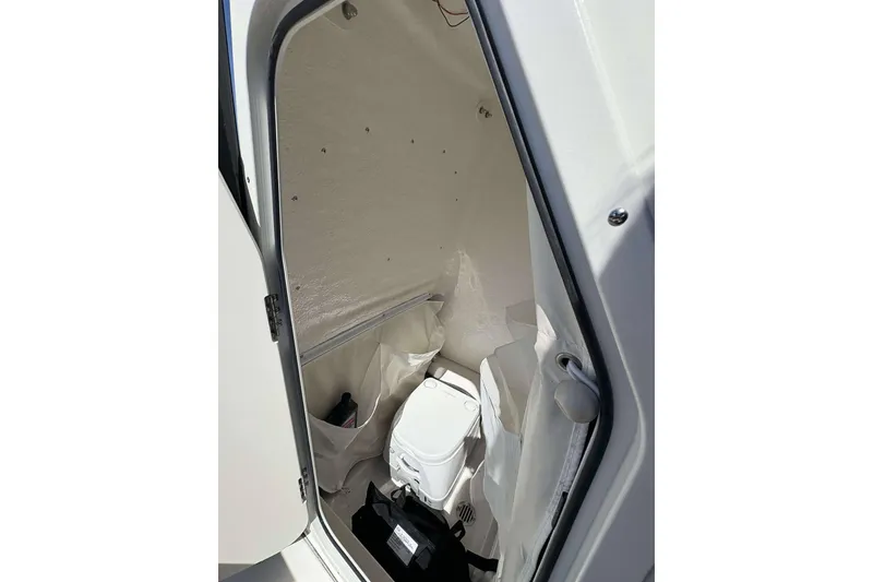 Slide: The Image of Interior of 2026 Key West 239 FS boat, featuring a compact marine toilet. - 20