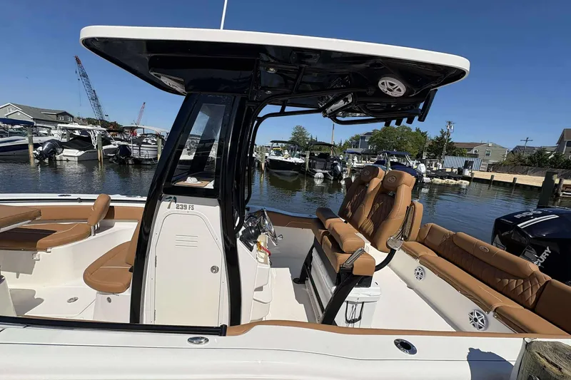 Slide: The Image of 2026 Key West 239 FS boat with tan seating, docked in a marina under clear skies. - 8