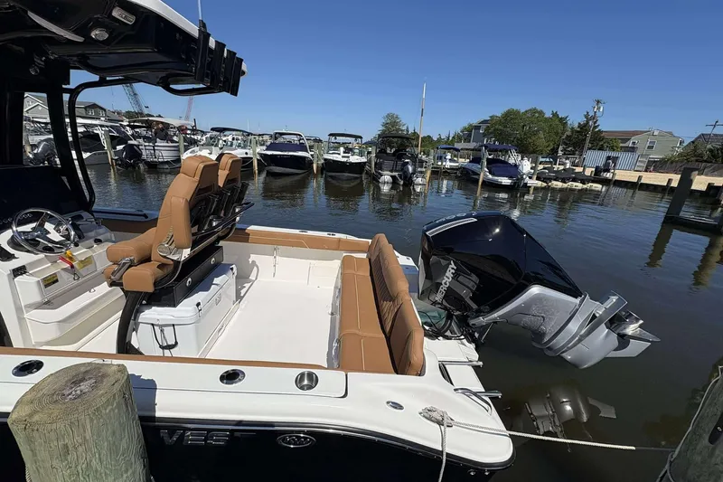 Slide: The Image of 2026 Key West 239 FS boat docked, featuring tan seating and a powerful outboard motor. - 9