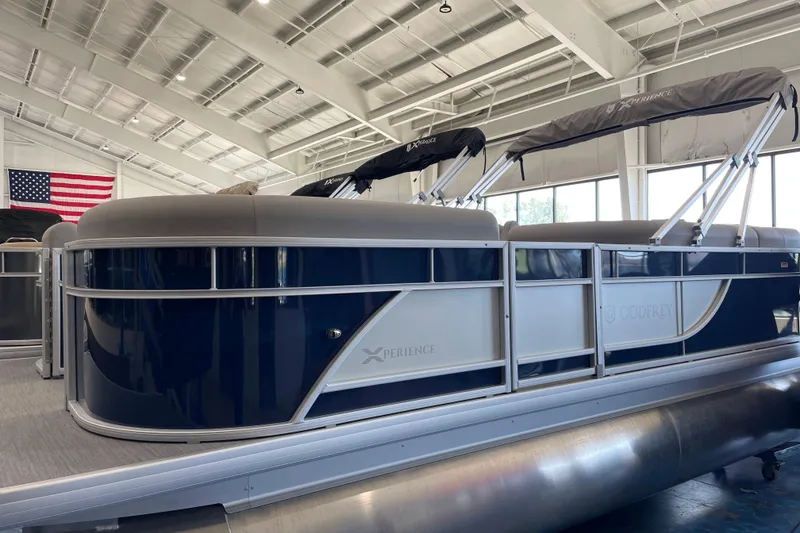 The Image of 2026 Godfrey Xperience 2086 CX pontoon boat in showroom with American flag. - 0