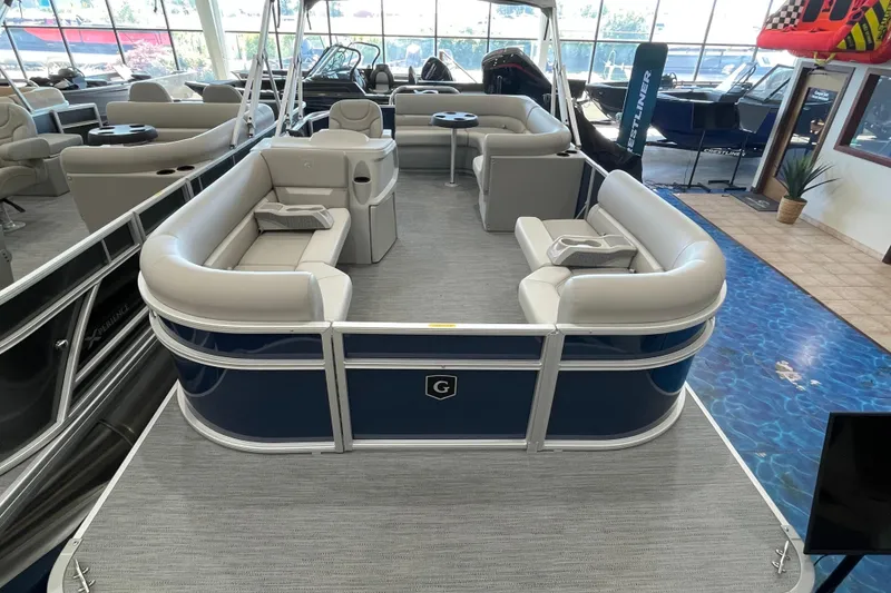 Slide: The Image of 2026 Godfrey Xperience 2086 CX pontoon boat with spacious seating in showroom. - 2