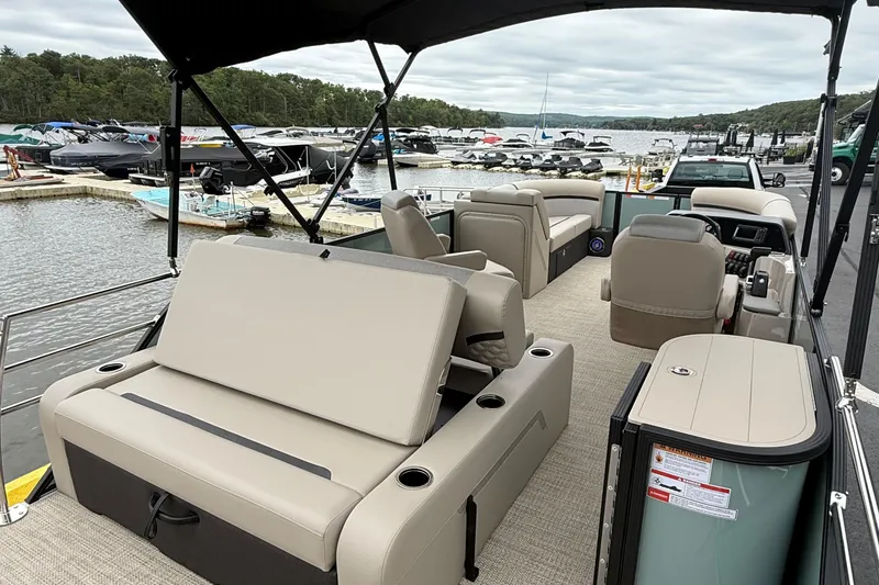 Slide: The Image of 2026 Crest 230 SLSC pontoon boat with beige seating, docked at a marina. - 4