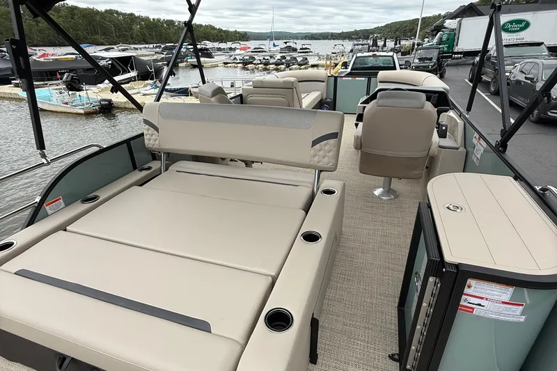 Slide: The Image of 2026 Crest 230 SLSC pontoon boat interior with beige seating and lake view. - 5