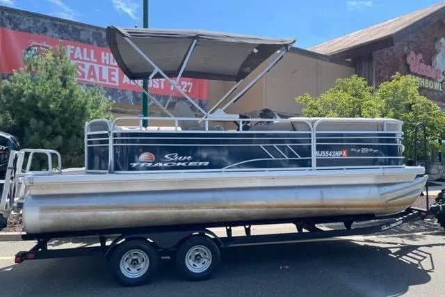 The Image of 2022 Sun Tracker Party Barge 20 DLX pontoon boat on trailer, outdoor setting. - 0