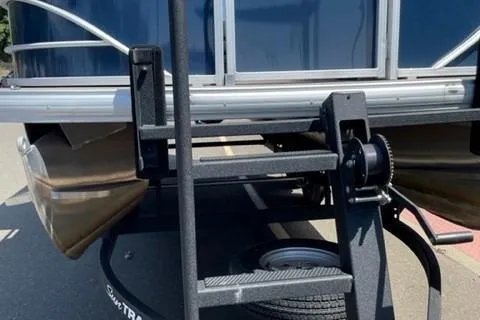 Slide: The Image of 2022 Sun Tracker Party Barge 20 DLX pontoon boat on trailer, close-up view. - 13