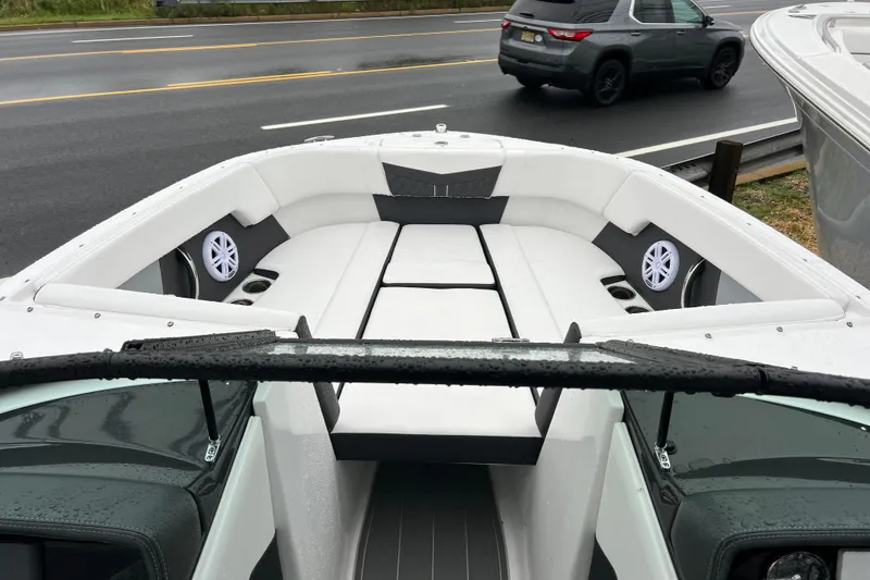 Slide: The Image of 2026 Monterey M-225 boat interior with white seating and speakers, parked near a road. - 17