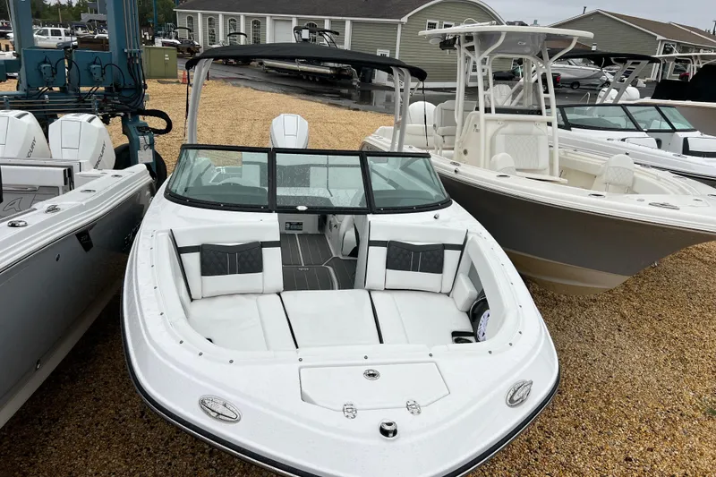 Slide: The Image of 2026 Monterey M-225 boat with sleek white design and spacious seating, displayed outdoors. - 22