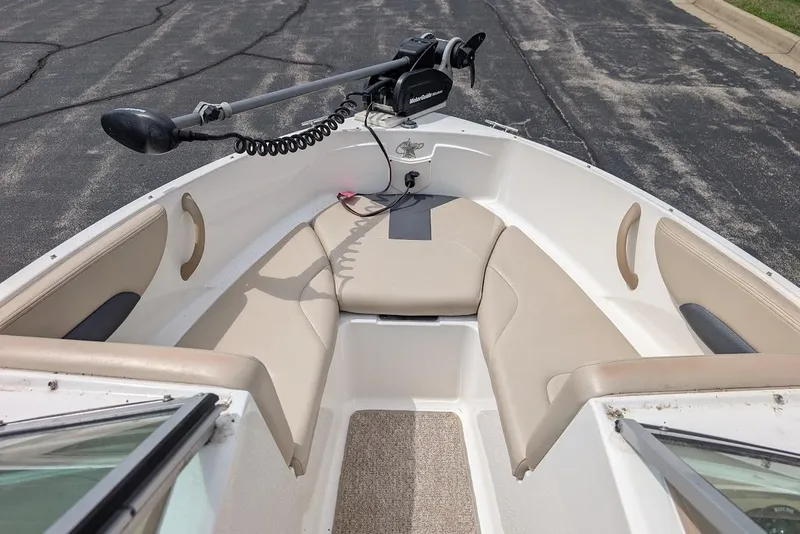 Slide: The Image of 2012 Chaparral 18 H2O Ski & Fish boat interior with beige seating and trolling motor. - 10