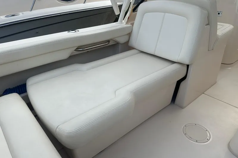 Slide: The Image of 2022 Grady-White Freedom 275 boat interior with white cushioned seating and sleek design. - 13