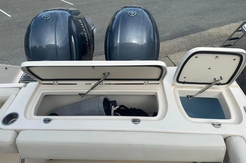 Slide: The Image of 2022 Grady-White Freedom 275 boat with open storage compartments and dual Yamaha engines. - 16