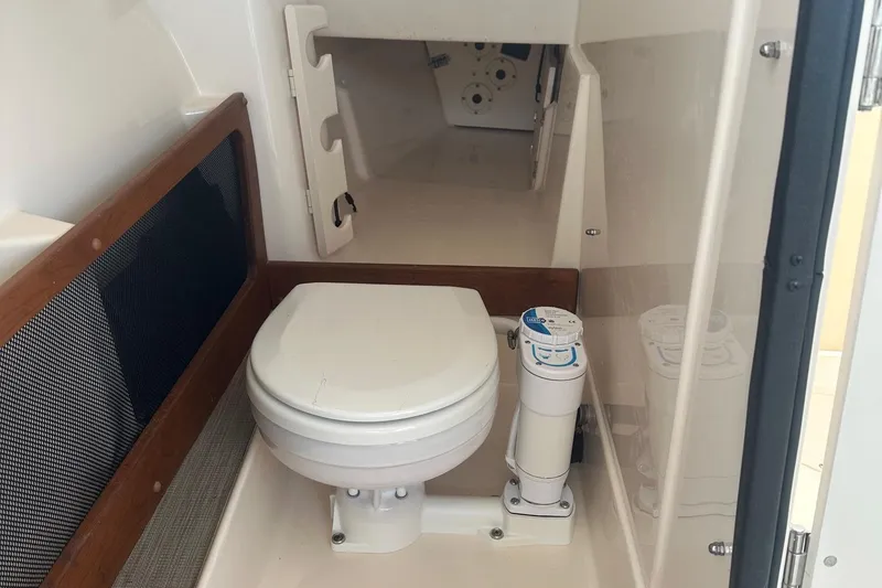 Slide: The Image of 2022 Grady-White Freedom 275 boat interior with compact marine toilet. - 19