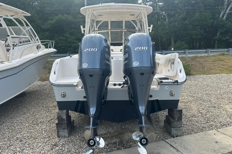 Slide: The Image of 2022 Grady-White Freedom 275 boat with dual Yamaha 200 engines, parked on gravel. - 3