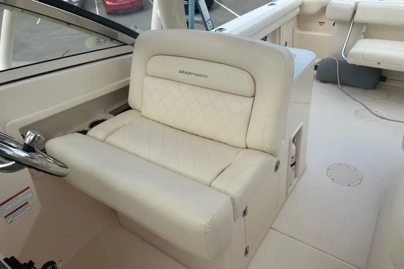 Slide: The Image of 2022 Grady-White Freedom 275 boat interior with luxurious seating and steering wheel. - 7